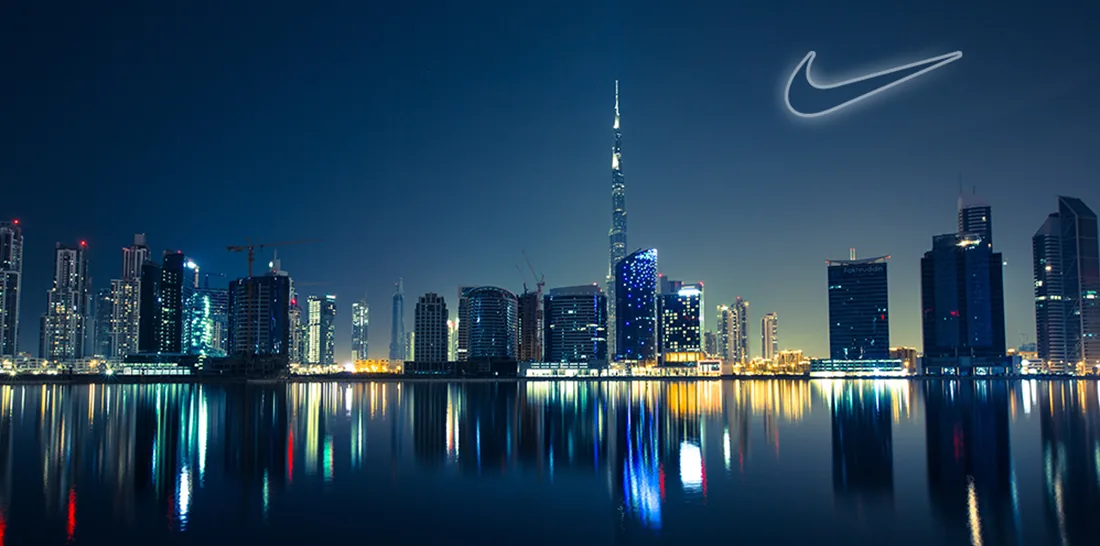 Montage illustrant un logo publicitaire lumineux au-dessus d’une ville de nuit