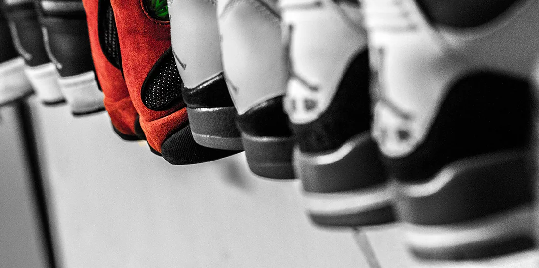 Une paire de chaussures rouges se distingue dans un alignement de chaussures